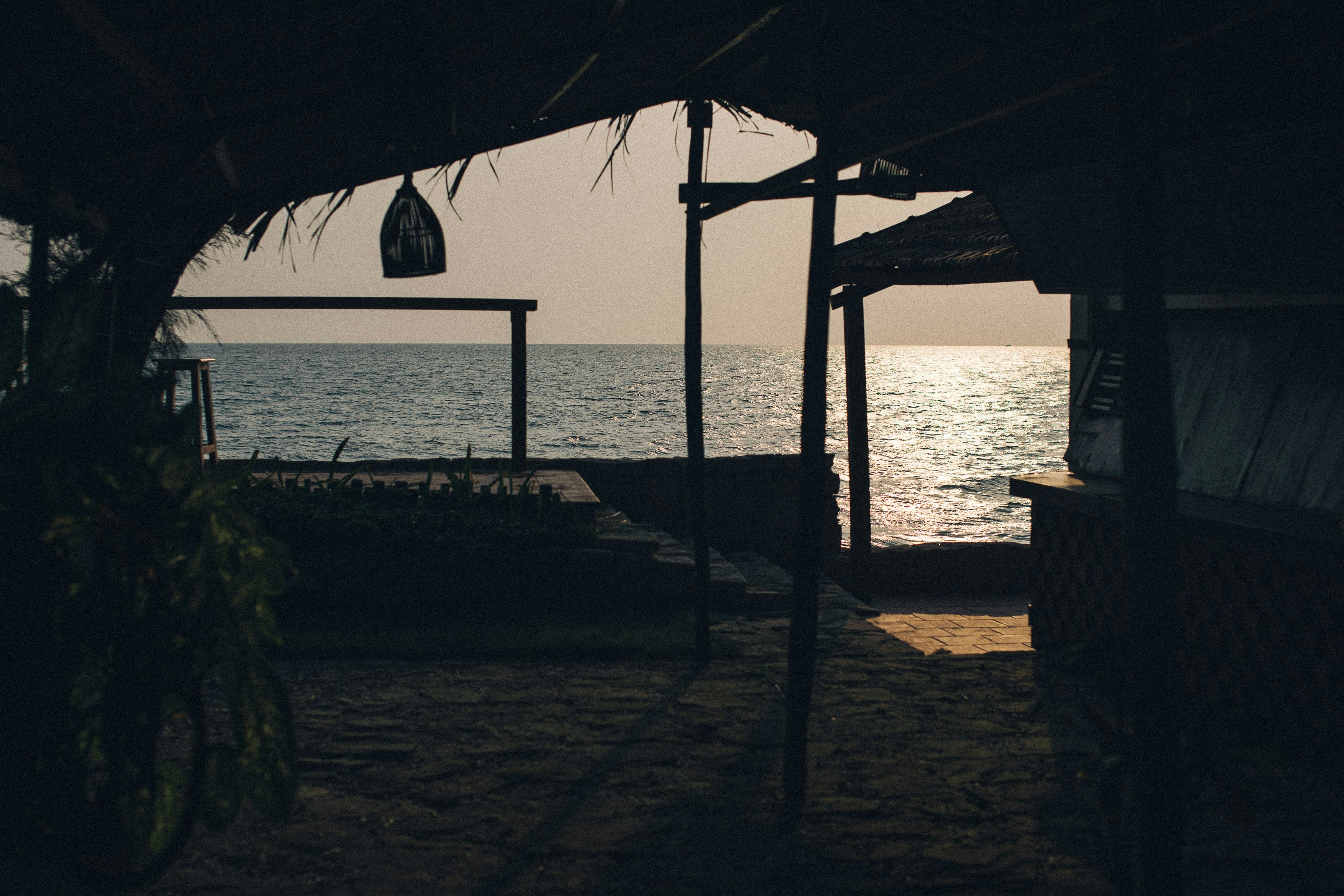 silhouette of person standing on beach during sunset